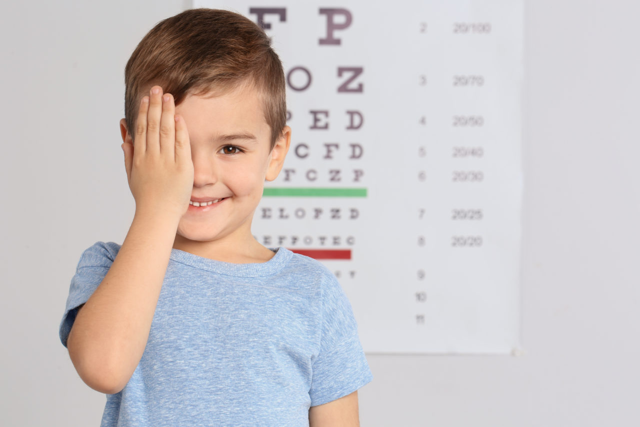 Chłopiec u okulisty zasłania jedno oko