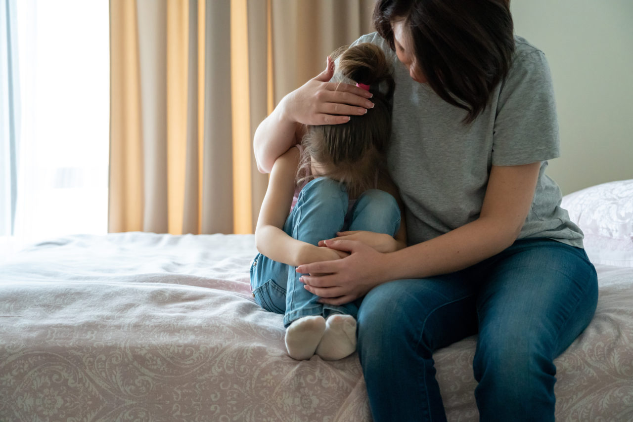 Mama przytula smutną córeczkę, oferując wsparcie