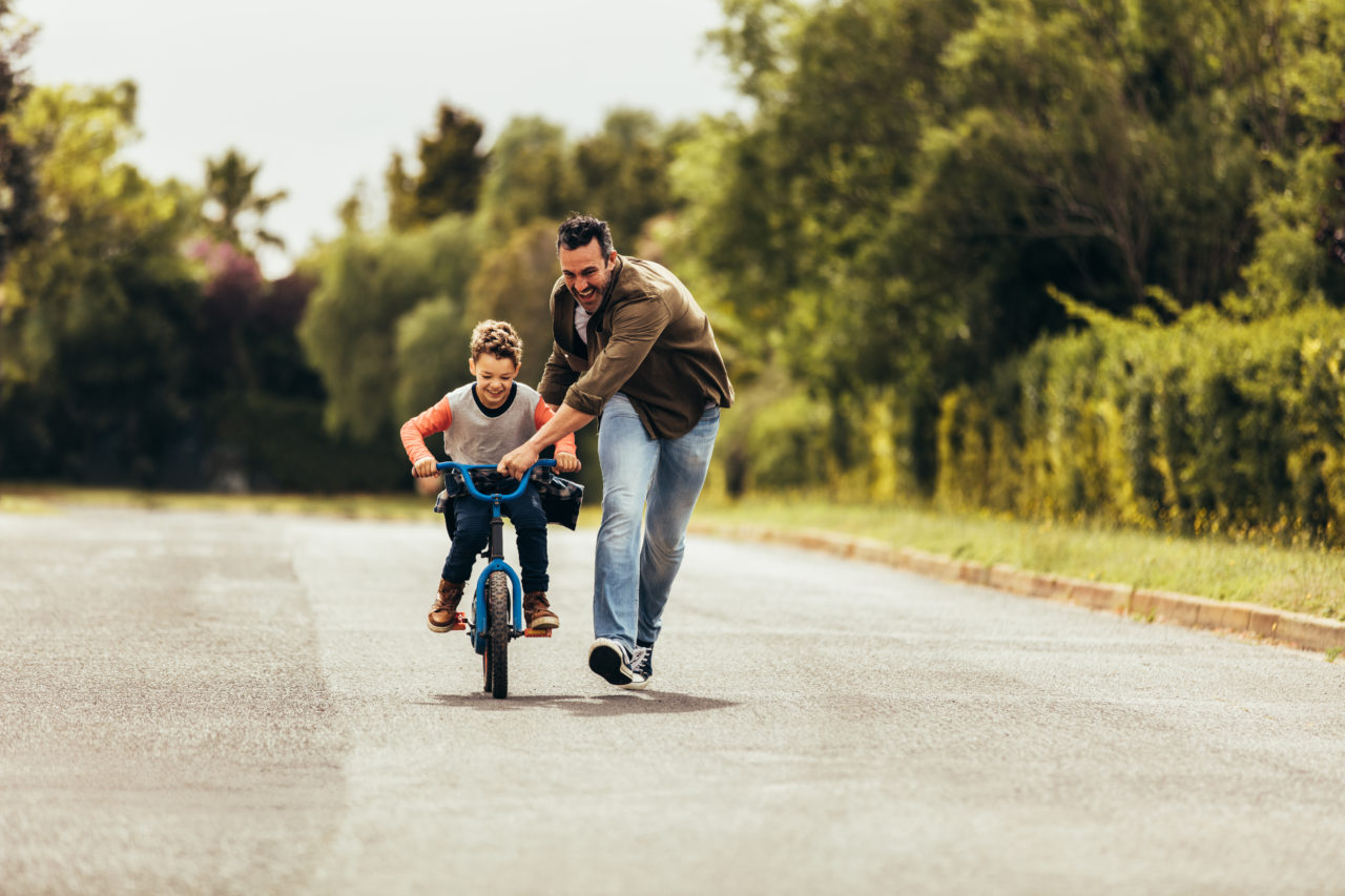 Tata uczy syna jazdy na rowerze