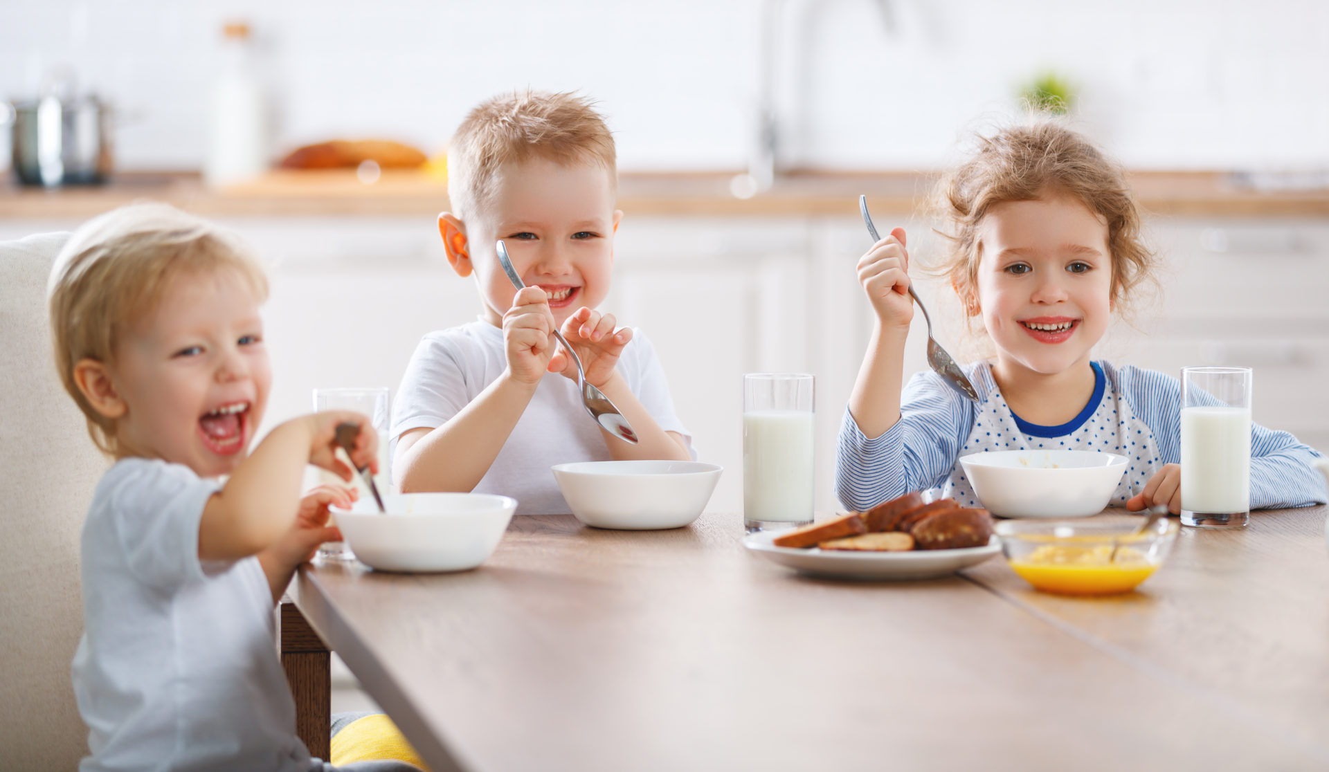 Roześmiane dzieci zjadają śniadanie